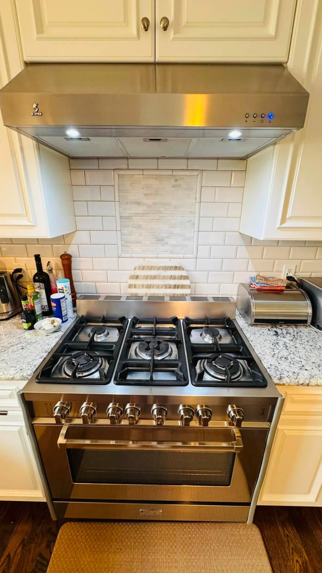 Full kitchen with clean cooktop and hood